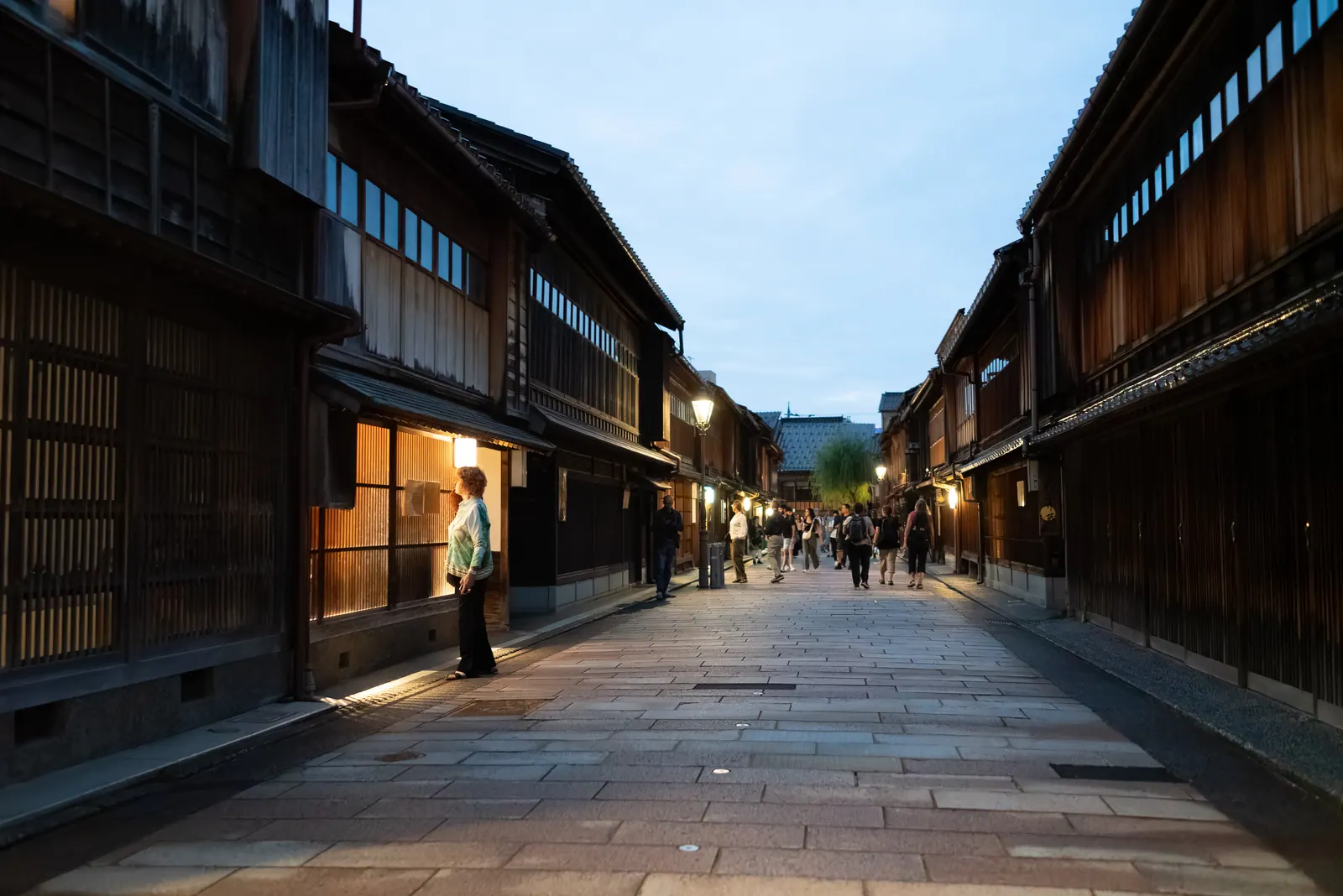 A street of wooden teahouses in early evening light.