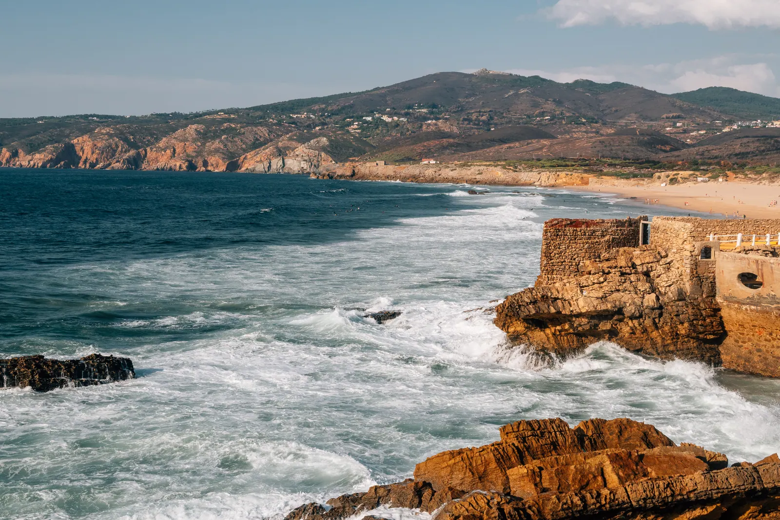 Waves breaking against rocks along a curving Atlantic coastline.