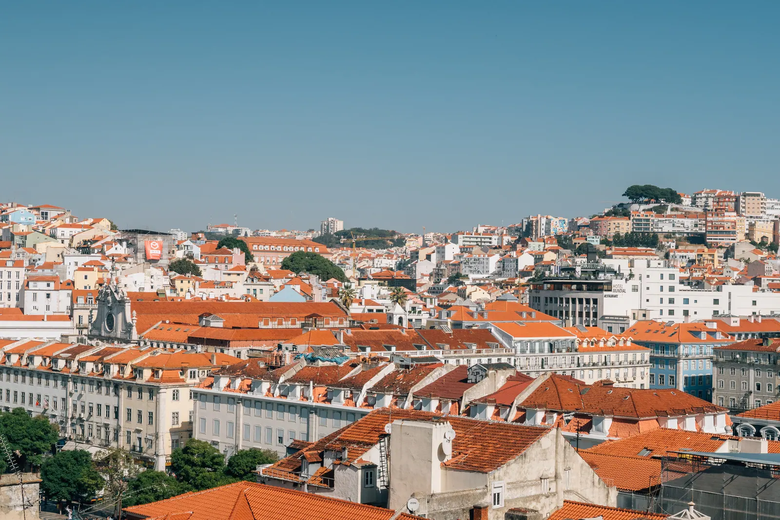 Red roofs of the city stepping down a hillside in bright sun.
