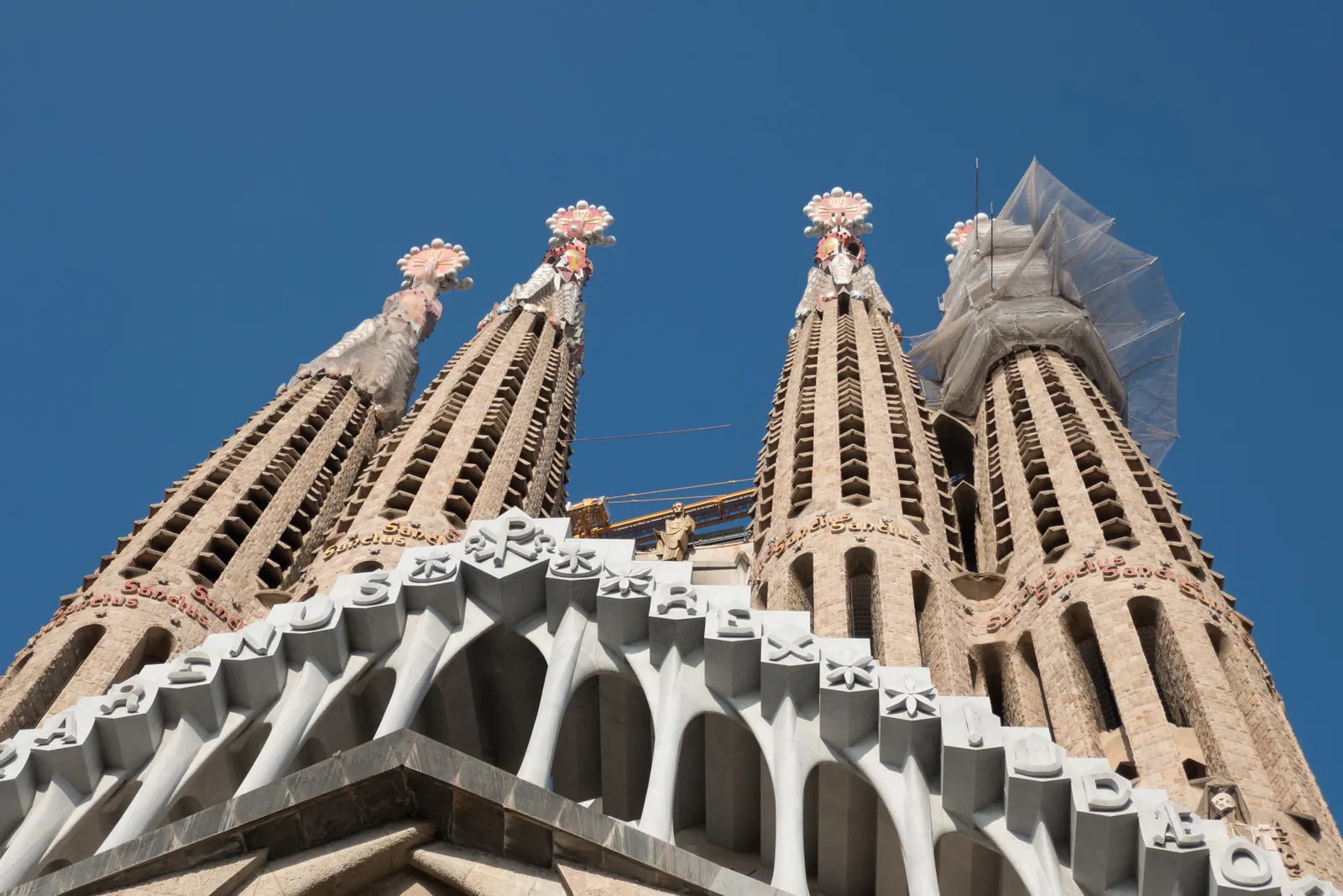 Looking up at the spires of a basilica against a deep blue sky.